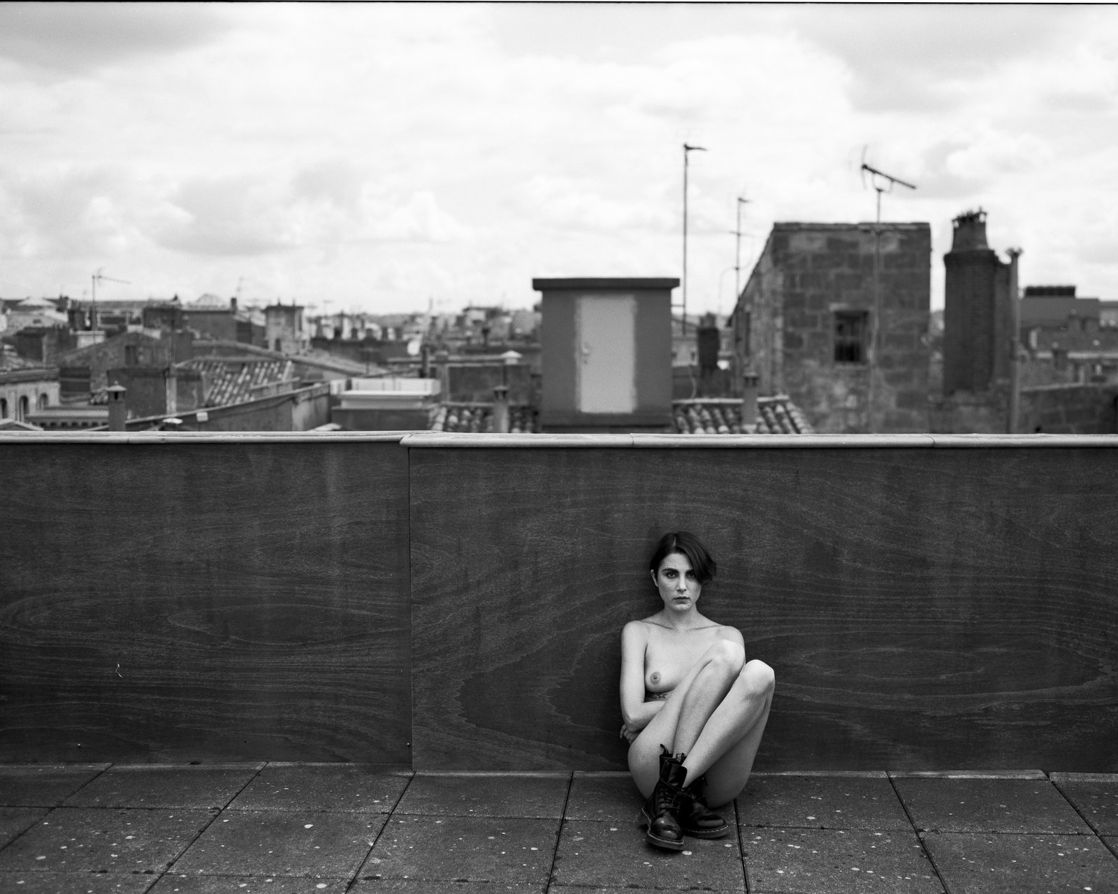 Femme assise sur un toit, vue urbaine