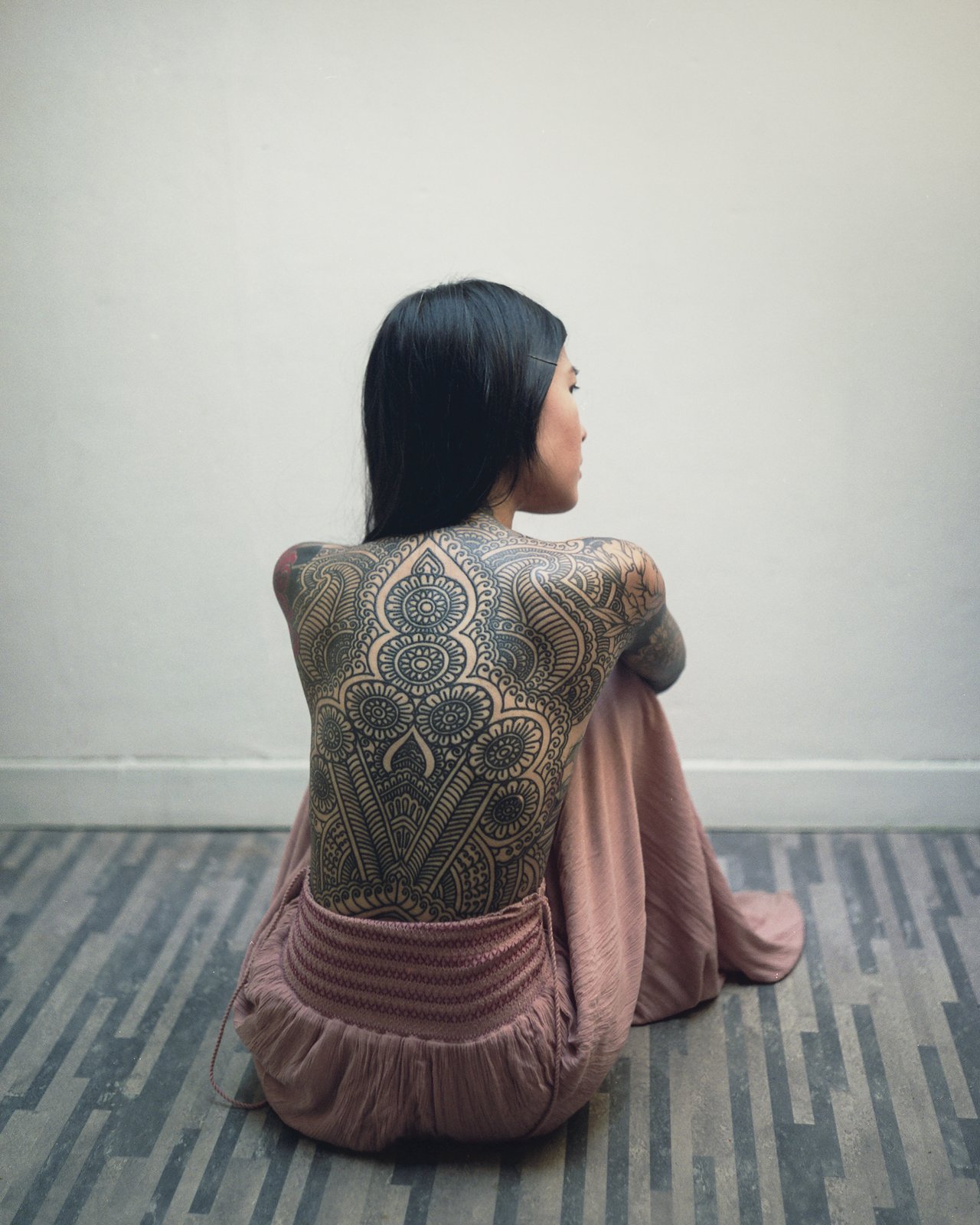 Nu assis de dos, tatouage dans le dos