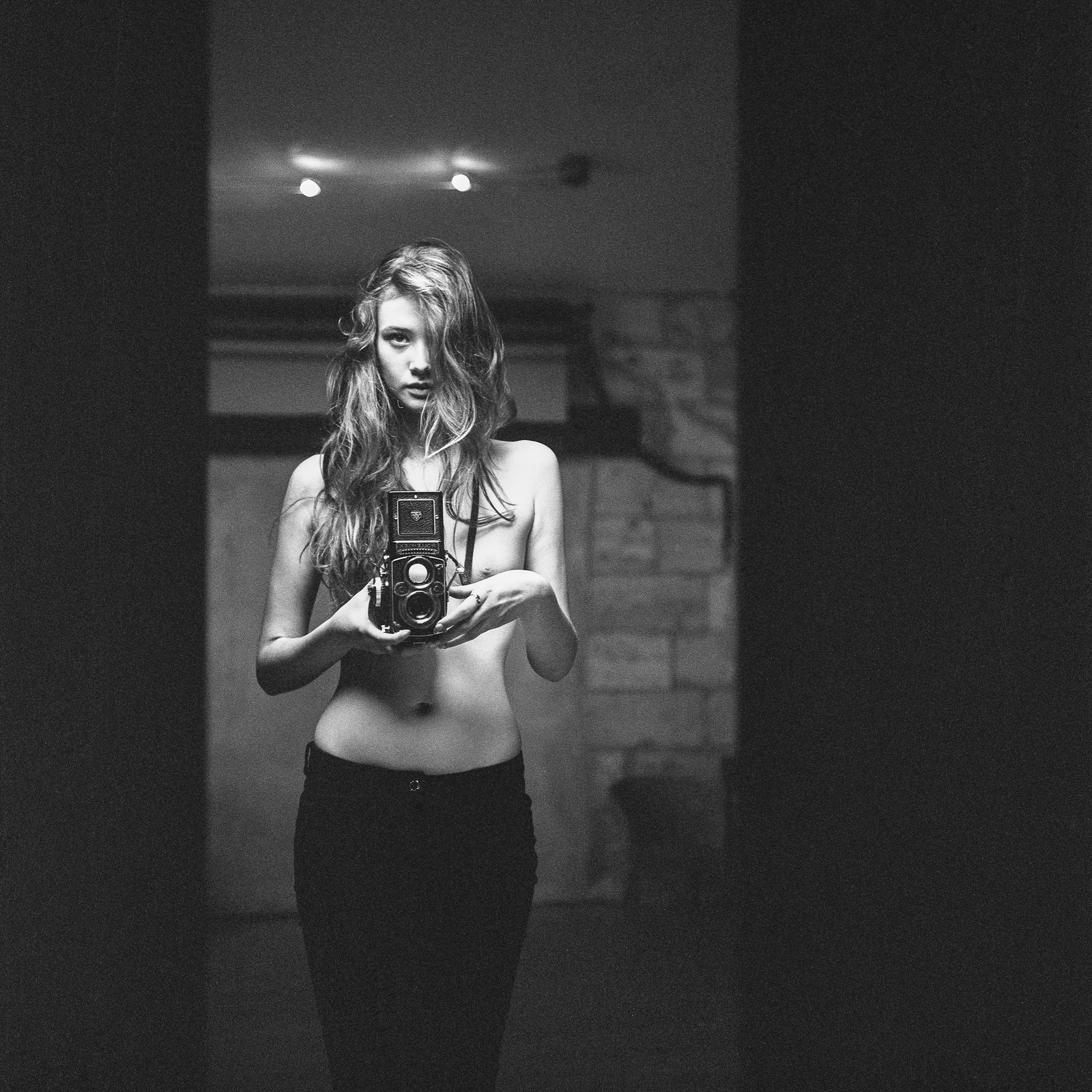 Nu tenant un appareil photo argentique