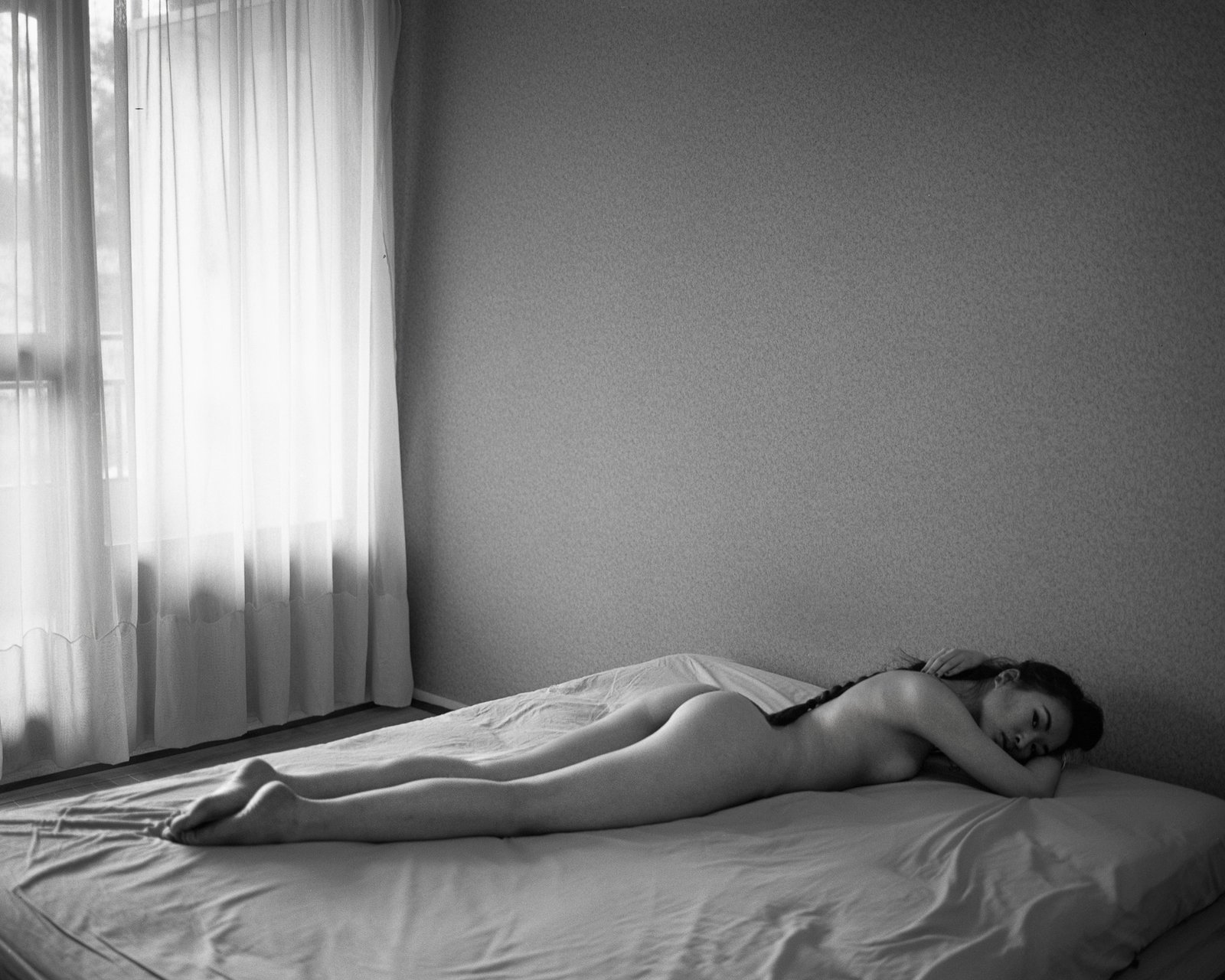Nu allongé sur un lit, lumière tamisée