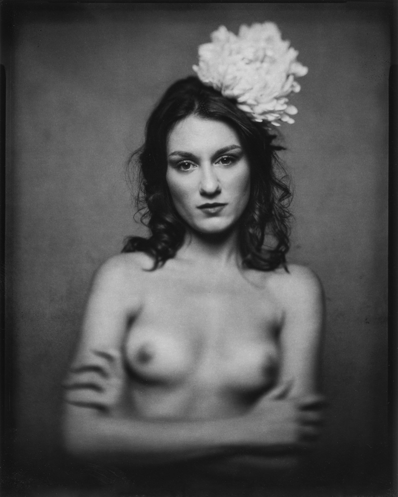 Nu, fleur dans les cheveux, bras croisés