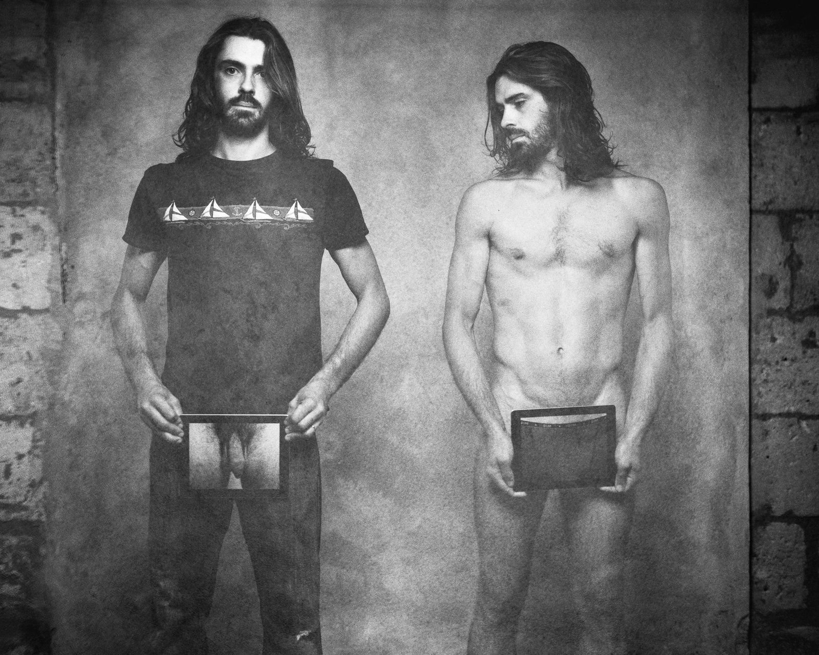 Duo masculin, t-shirt noir et torse nu, cadre en main