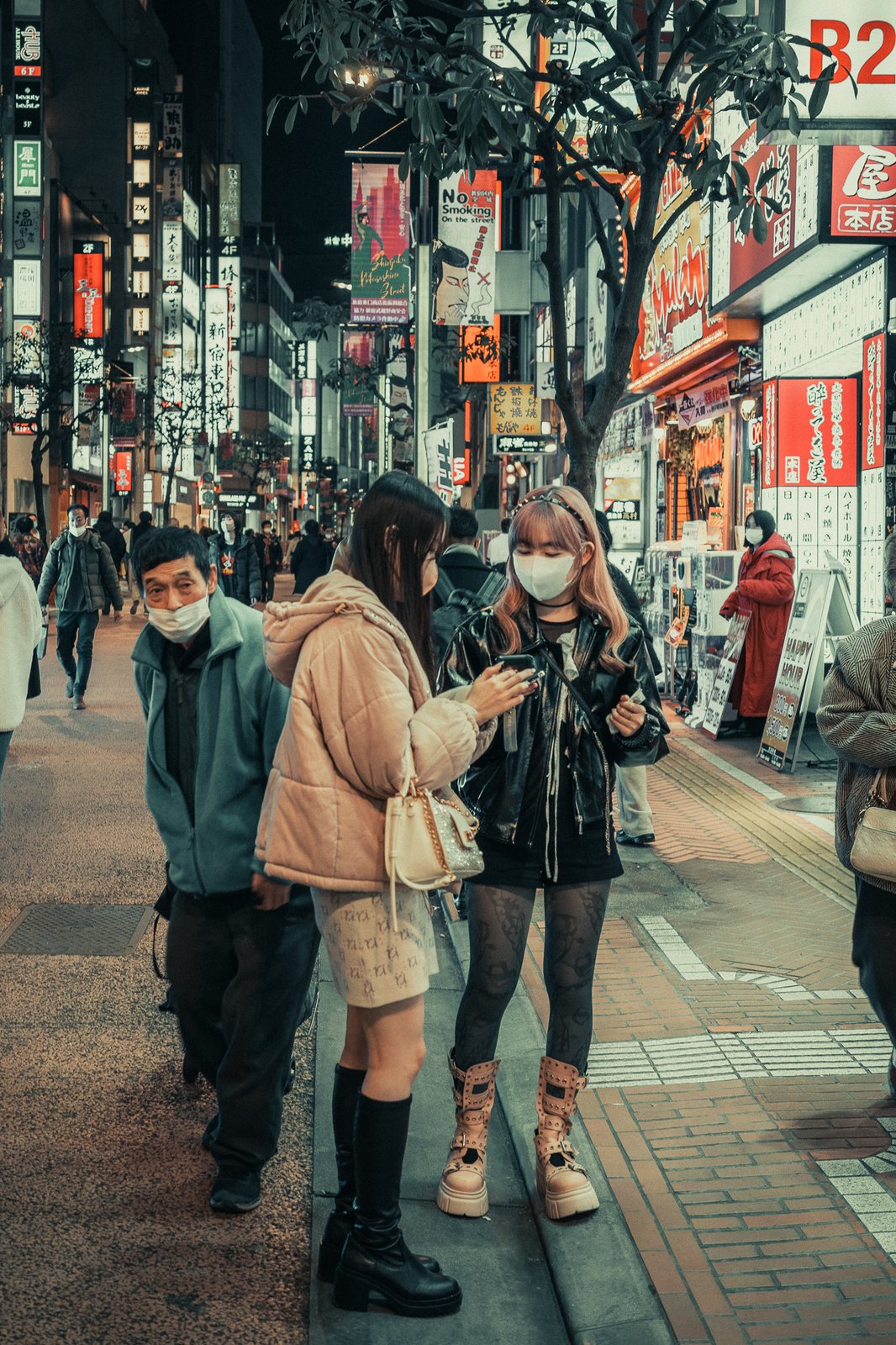 Deux jeunes femmes dans une rue animée la nuit, néons japonais, Tokyo