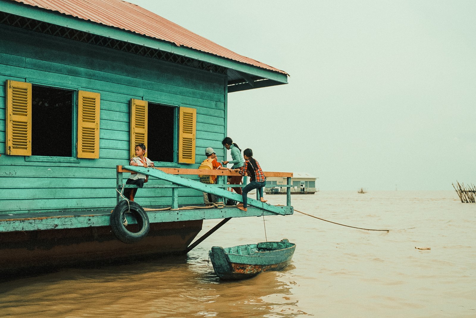 Maison sur pilotis et enfants sur un ponton, village flottant