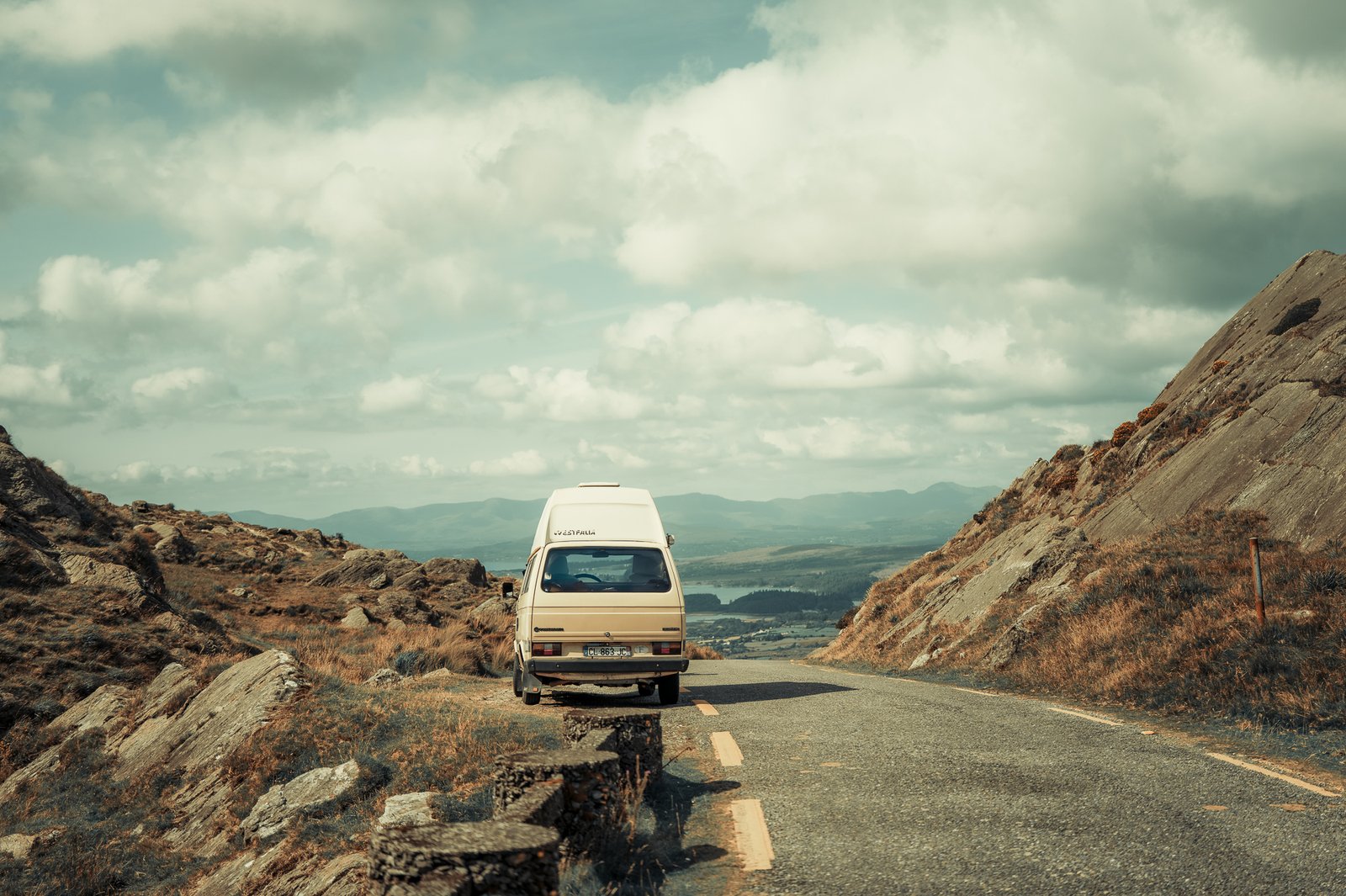 Camping-car sur une route de montagne, paysage vallonné