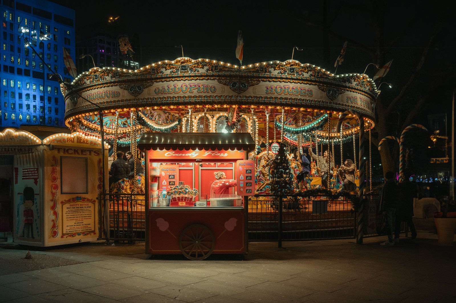 Carrousel de fête foraine et stand de barbe à papa la nuit