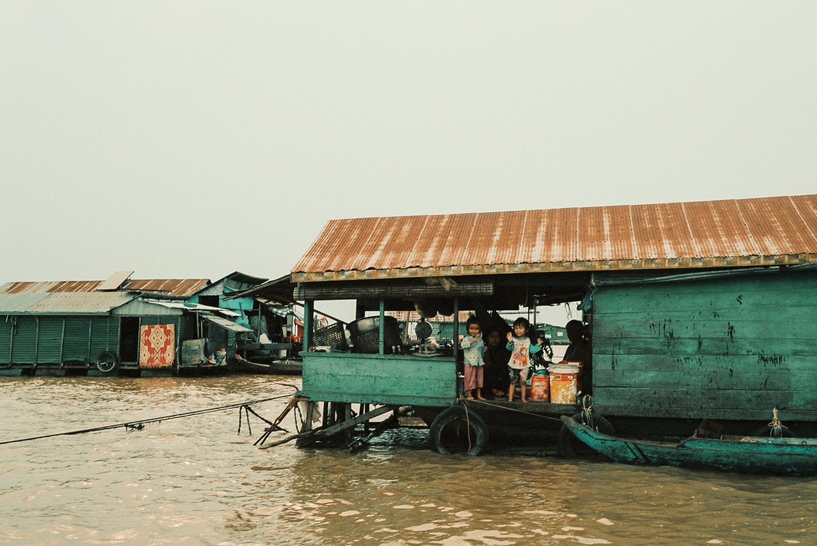 Maison flottante et enfants sur un ponton, village lacustre du Tonlé Sap