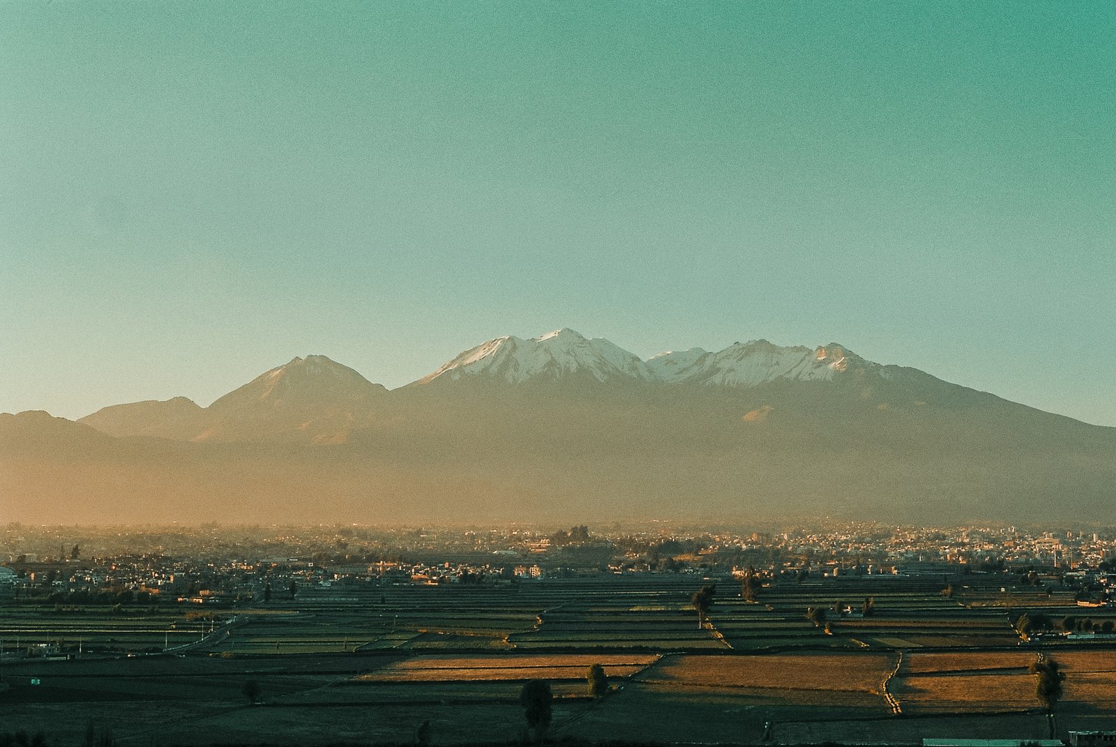 Ville nichée au pied d'un volcan enneigé