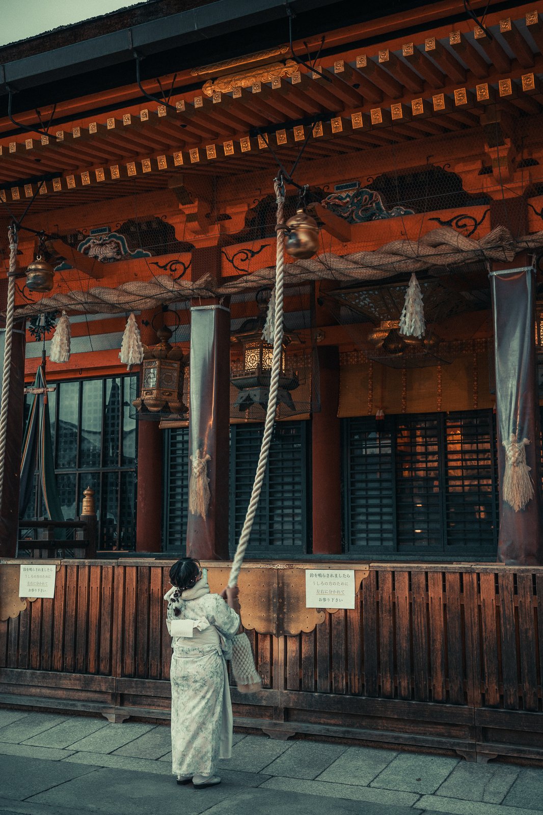Femme en kimono actionnant la cloche d'un temple, Kyoto