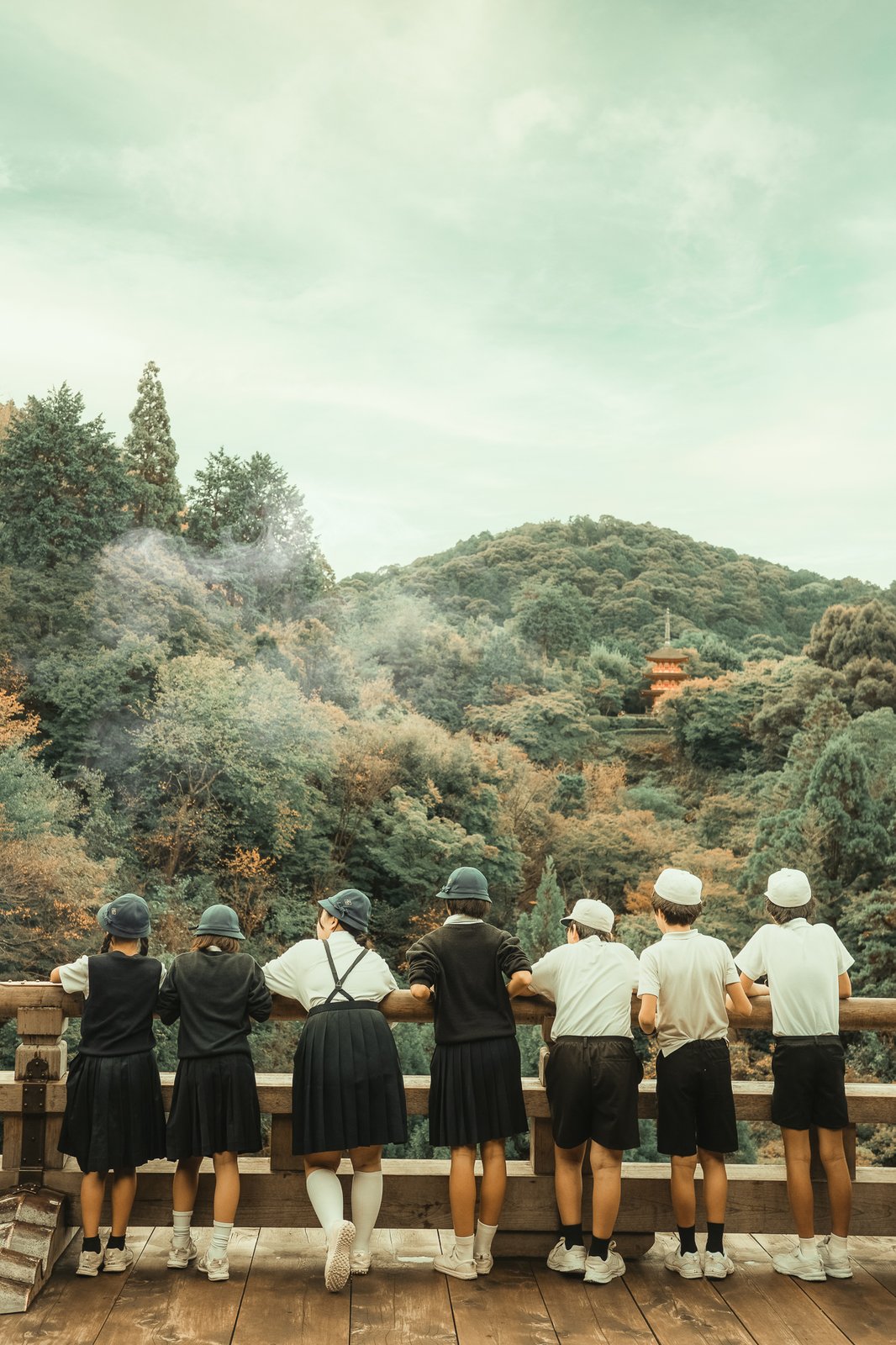 Écoliers en uniforme accoudés à une rambarde, pagode au loin, Japon