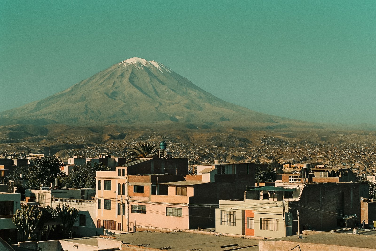 Volcan enneigé dominant les toits de la ville
