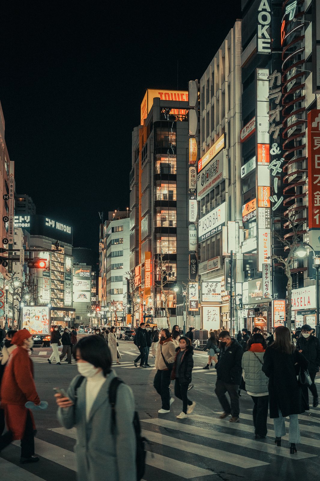 Carrefour piétons bondé la nuit, néons japonais